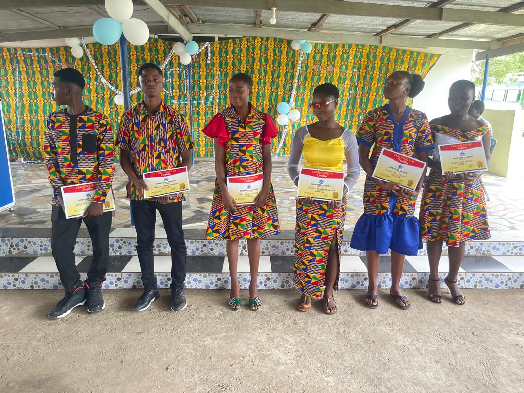 ROSA students holding certificates on a stage